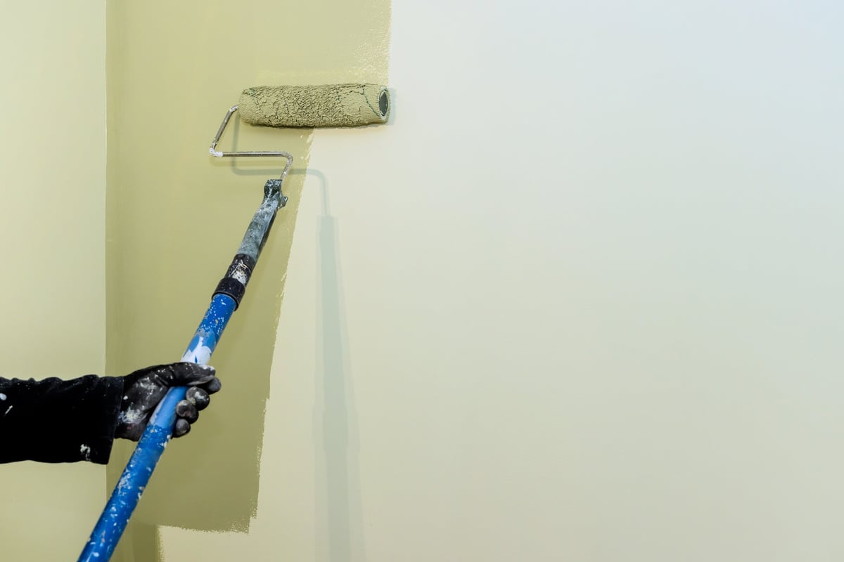 Professional painter applying paint to wall