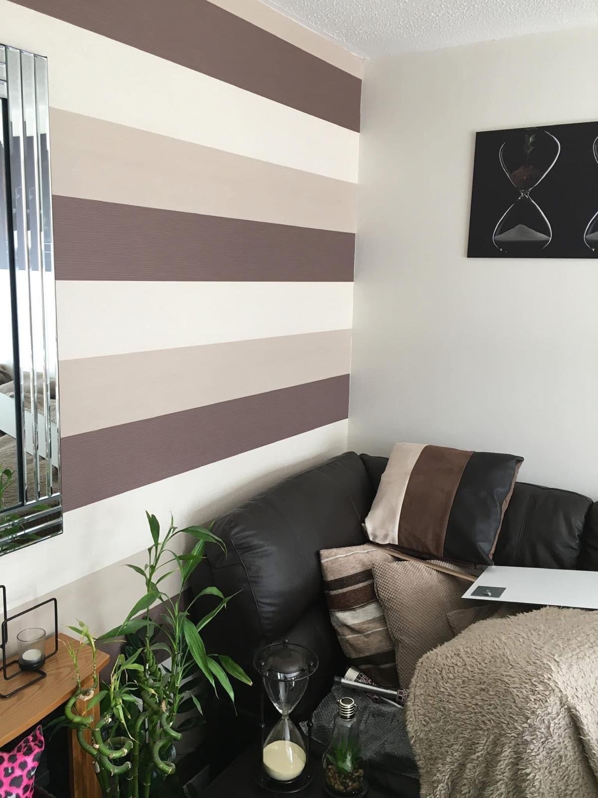 Modern bedroom corner with striped brown and white accent wall