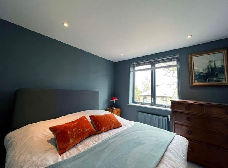 Stylish bedroom with dark teal accent walls
